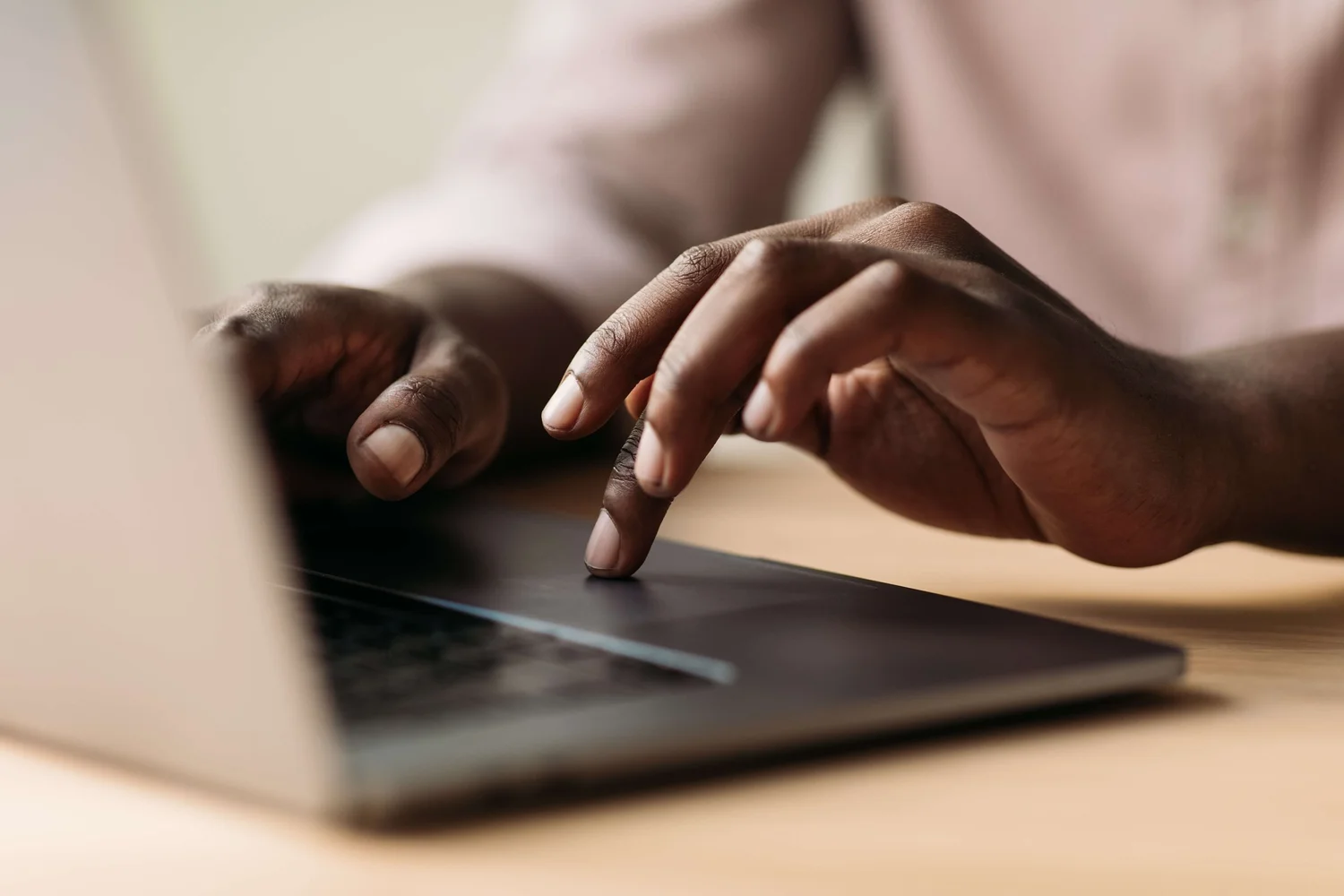Hands using a laptop trackpad